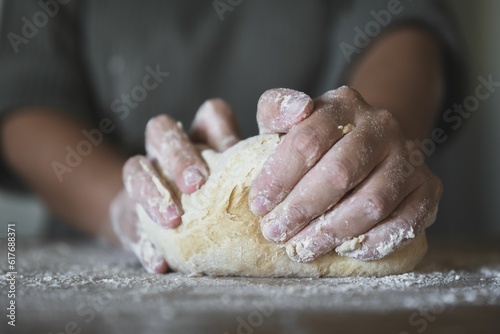 Closeup shot of a person kneading dough on a kitchen counterto