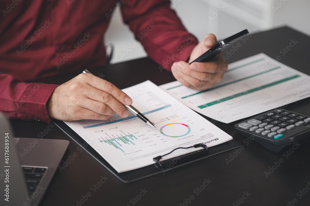 Business man pointing to a pie chart document showing company financial information, He sits in her private office, a document showing company financial information in chart form. Financial concepts. Business man pointing to a pie chart document showing company financial information, He sits in her private office, a document showing company financial information in chart form. Financial concepts.