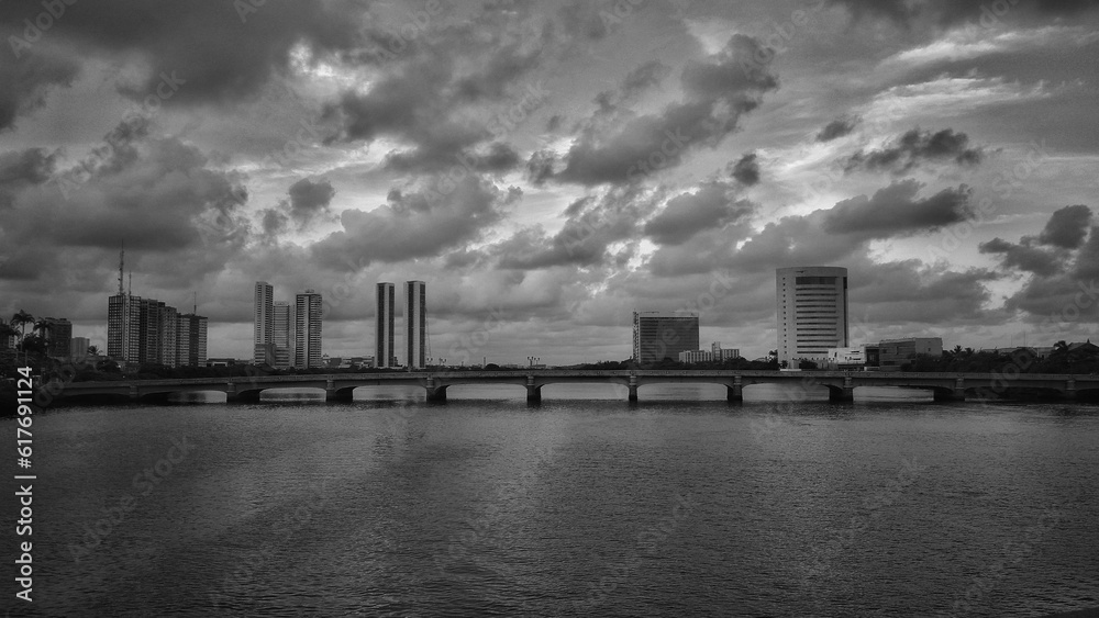 Black and white photograph of a city skyline, featuring the silhouettes of tall buildings