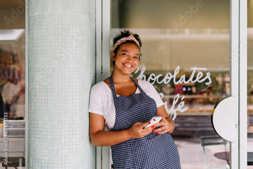 Cafe owner using smartphone in small business