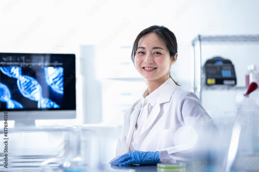 Researcher woman wearing a white lab coat and sitting in a laboratory Researcher woman wearing a white lab coat and sitting in a laboratory