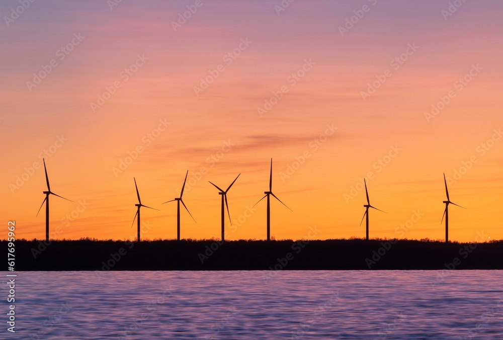 Landscape of windmills surrounded by the sea during the sunset in the evening