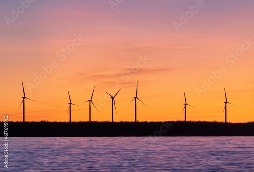 Landscape of windmills surrounded by the sea during the sunset in the evening