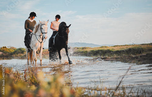 Horse riding, friends and girls at lake in countryside with outdoor mockup space. Equestrian, happy women and animals in water, nature and adventure to travel, journey and summer vacation together. © Kirsten Davis/peopleimages.com