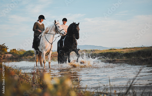 Horse riding, friends and women at lake in countryside with outdoor mockup space. Equestrian, happy girls and animals in water, nature and adventure, travel and journey for summer vacation together. © Kirsten Davis/peopleimages.com
