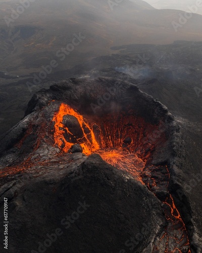 View of Fagradalsfjall volcano crater in Iceland, with a vibrant orange hue emitting from the lava