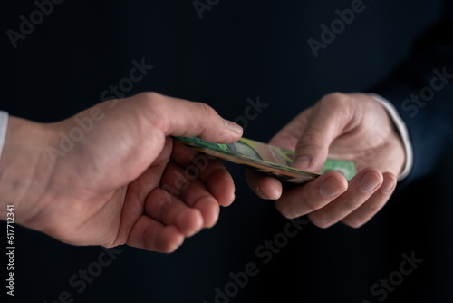Business man in formal suit hand hold money spread of cash giving money.