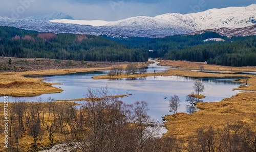 Tranquil Scottish landscape featuring a tranquil body of water surrounded by majestic mountains