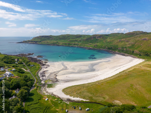 An aerial drone photo of Calgary Bay. This beautiful beach can be found on the Isle of Mull in Scotland. The beach has white sand and turquoise water. 