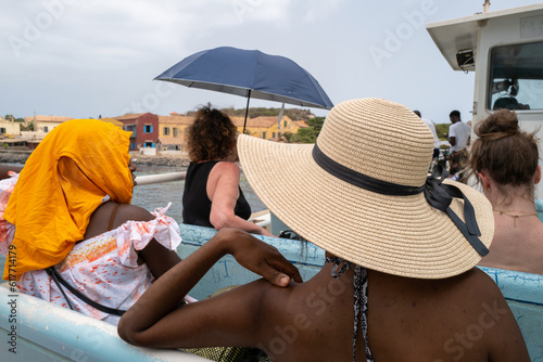 Des femmes se protègent du soleil avec un chapeau, un foulard et une ombrelle sur un bateau photo