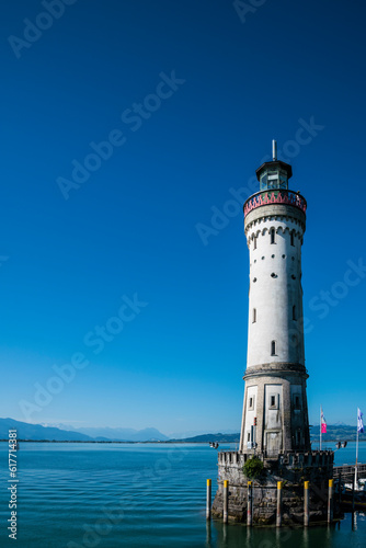 Obraz na płótnie Germany, Lindau harbour lighthouse and beautiful view to austrian alps mountains, early morning after sunrise, silent water and blue sky w salonie
