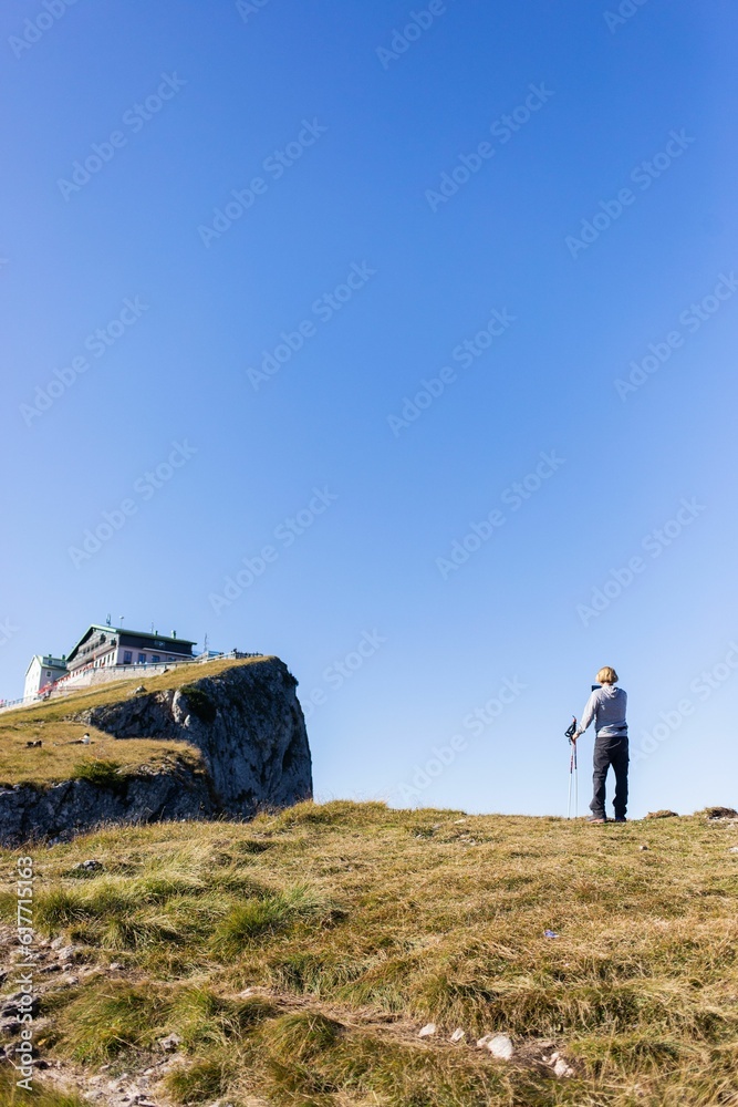 Female hiker taking photos of a house atop Schafberg in Salzburg, Austria Female hiker taking photos of a house atop Schafberg in Salzburg, Austria