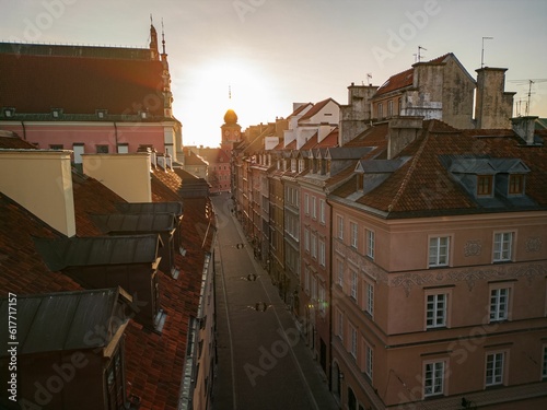 Idyllic city street scene with buildings illuminated by the light of the setting sun, Warsaw, Poland