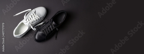 White and black leather shoes on a black background. sneakers with laces. New shoes. Horizontal image. Banner for insertion into site.