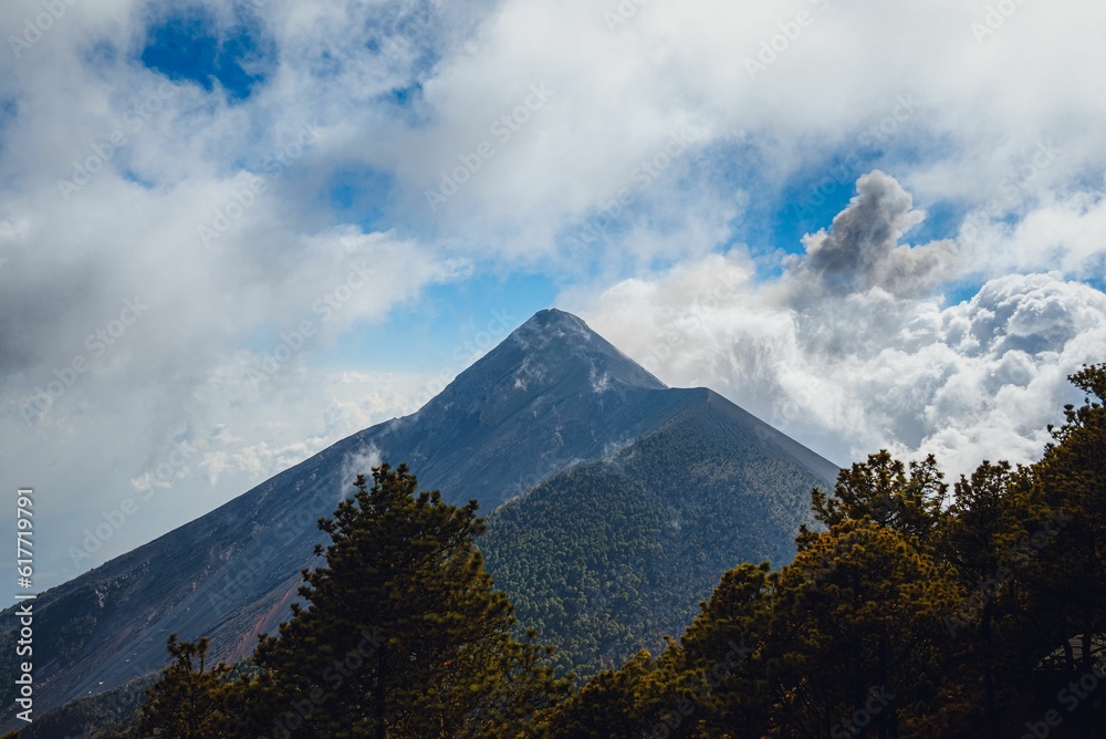 Dramatic view of El Fuego volcano in Antigua, Guatemala covered in white clouds