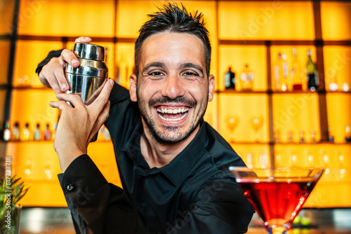Foto Handsome barman making cocktail at nightclub - Happy bartender working behind th