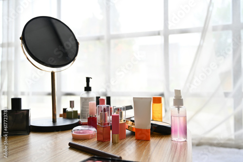 Round mirror, lotion bottle and skincare product on dressing table