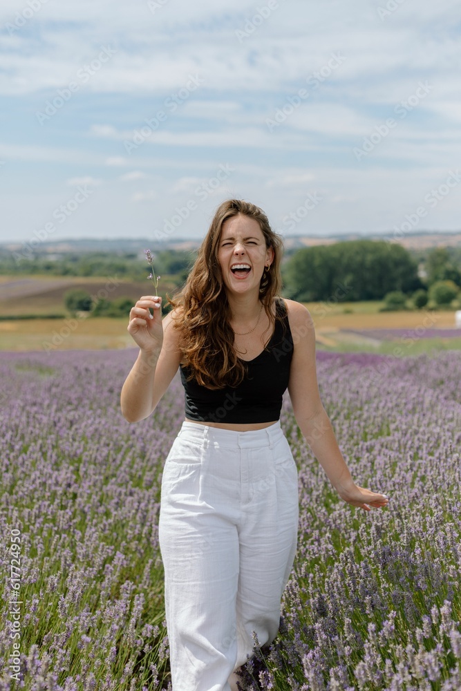 Cheerful young female in a lavender field on a sunny day