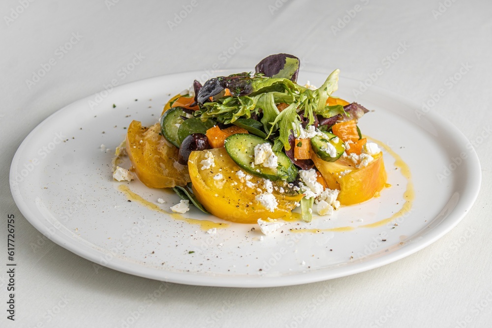 White dinner plate with a vibrant array of vegetables and a creamy sauce garnish White dinner plate with a vibrant array of vegetables and a creamy sauce garnish