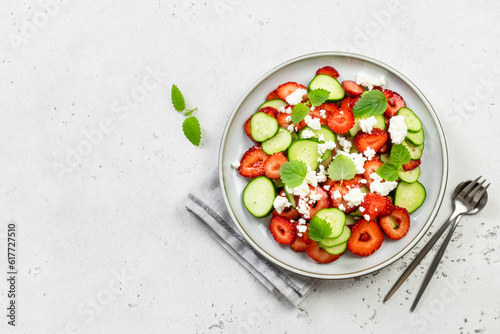 Low carb healthy cucumber strawberry goat cheese salad on plate. Top view, flat lay, copy space.