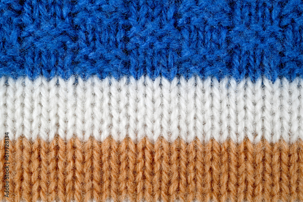 White, brown, blue color wool knitted background close up White, brown, blue color wool knitted background close up