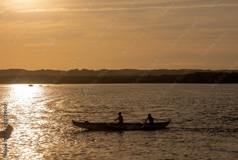 Obraz premium A silhouette of two people rowing in a boat