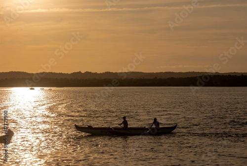 A silhouette of two people rowing in a boat