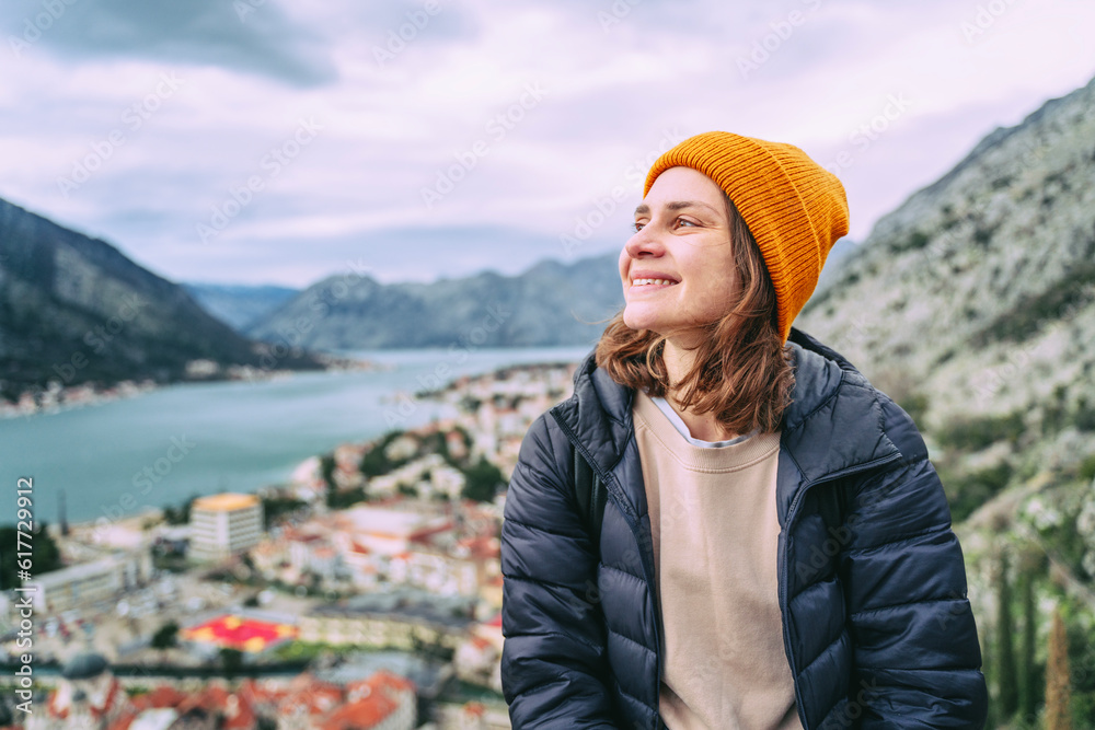 Young woman traveler enjoying the view of the old town of Kotor and the Bay, in Montenegro on an autumn day