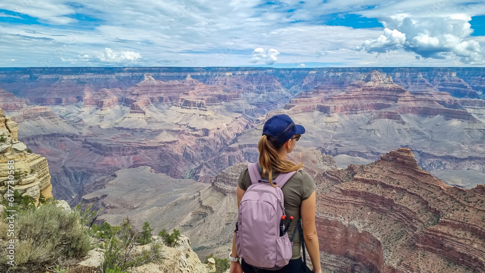 Woman with scenic view from Skeleton Point on South Kaibab hiking trail at South Rim, Grand Canyon National Park, Arizona, USA. Colorado River weaving through valleys and rugged terrain. O Neill Butte