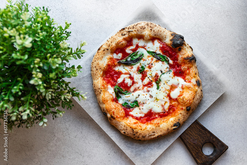 Neapolitan pizza Margarita with tomato sauce, mozzarella and basil cooked in the stone oven on a white background