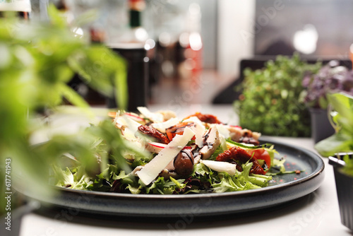 Salad with vegetables, cheese, olives, balsamic vinegar. Fresh healthy lunch on a black plate, selective focus.
