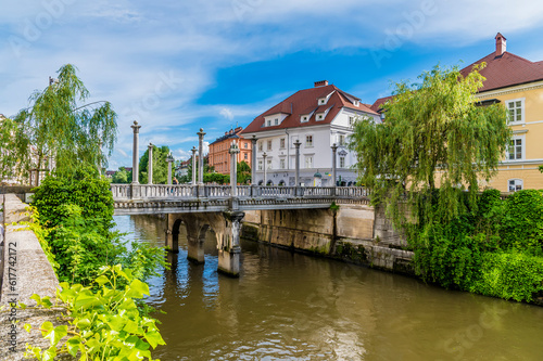 A view along the side of the River Ljubljanica towards the Shoemakers bridge in Ljubljana, Slovenia in summertime