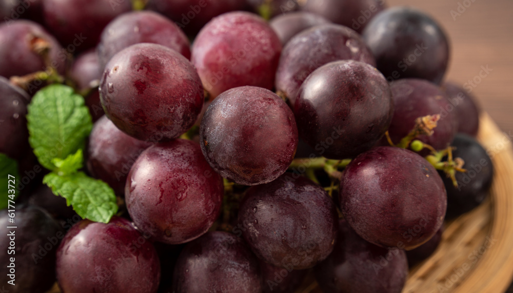 Delicious bunch of grapes fruit on a plate over wooden table background. Delicious bunch of grapes fruit on a plate over wooden table background.