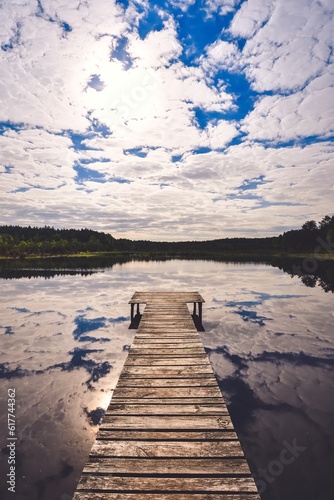 Beautiful summer afternoon landscape by the lake. Charming wooden pier over a small lake in Michala Gora, Poland. photo