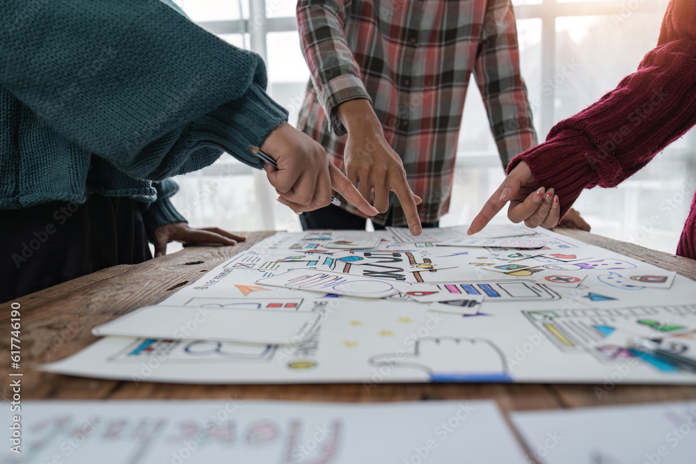 UX developer and ui designer brainstorming about mobile app interface wireframe design at modern office