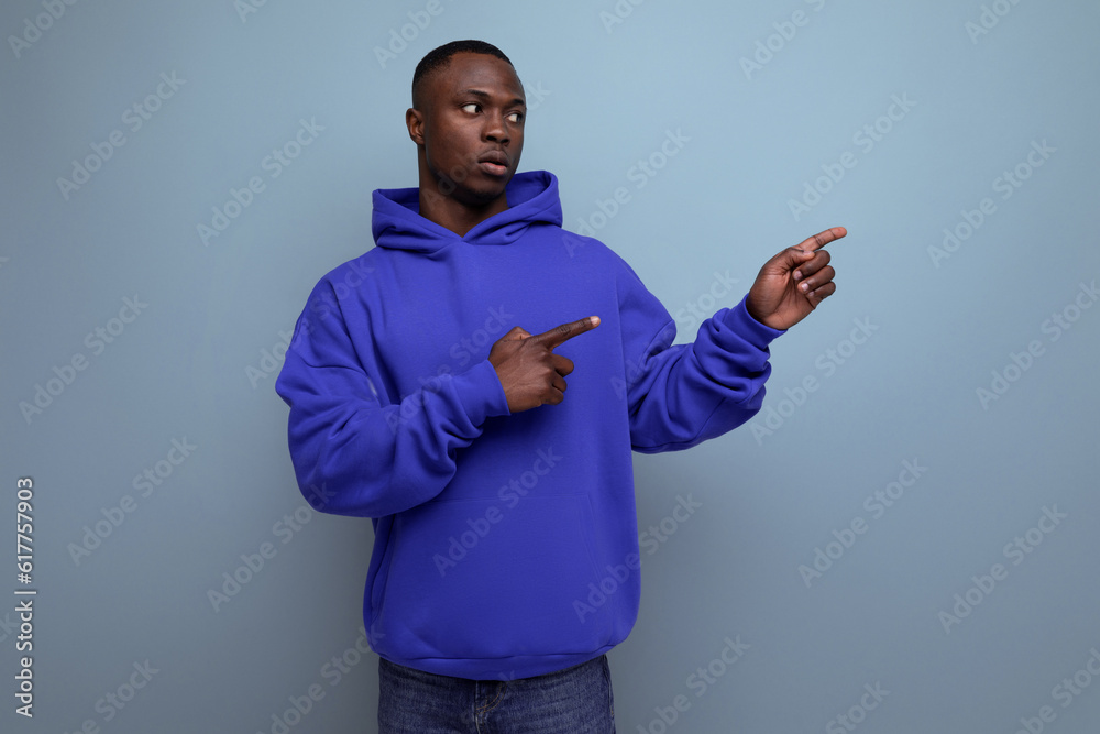 confident young black american man in casual clothes pointing to the side confident young black american man in casual clothes pointing to the side