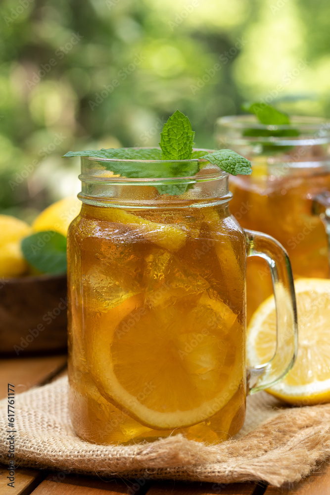 Ice tea in glass jars with lemon and mint Ice tea in glass jars with lemon and mint