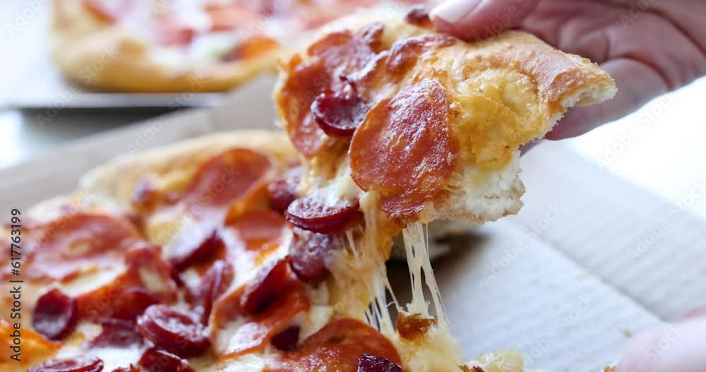 Female hand tears off piece of hot pizza. Food delivery home concept
