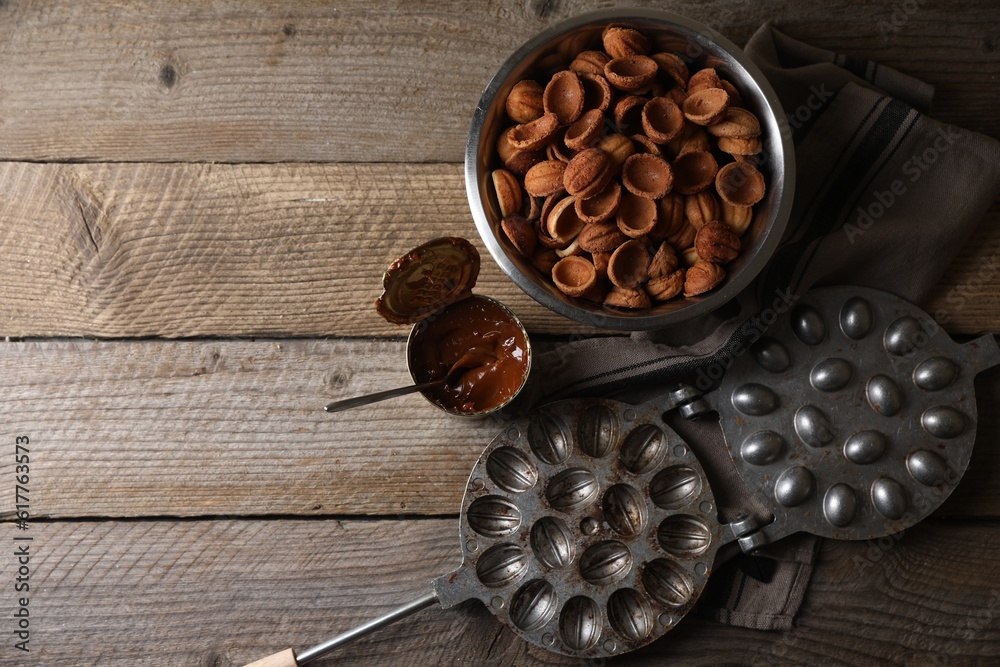 Making walnut shaped cookies. Cooked dough, caramelized condensed milk and mold on wooden table, flat lay. Space for text Making walnut shaped cookies. Cooked dough, caramelized condensed milk and mold on wooden table, flat lay. Space for text