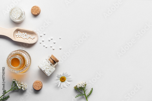 Homeopathic medicines and medicinal plants on a light background, copy space, flatlay