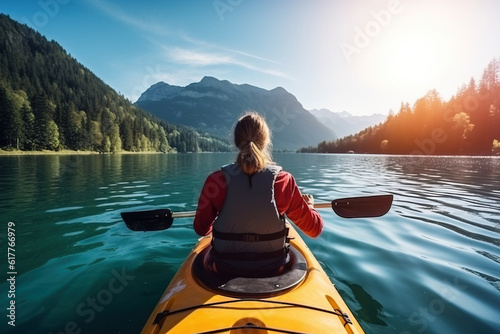 Back view of woman kayaking in crystal lake near alps. Generative AI © wolfhound911