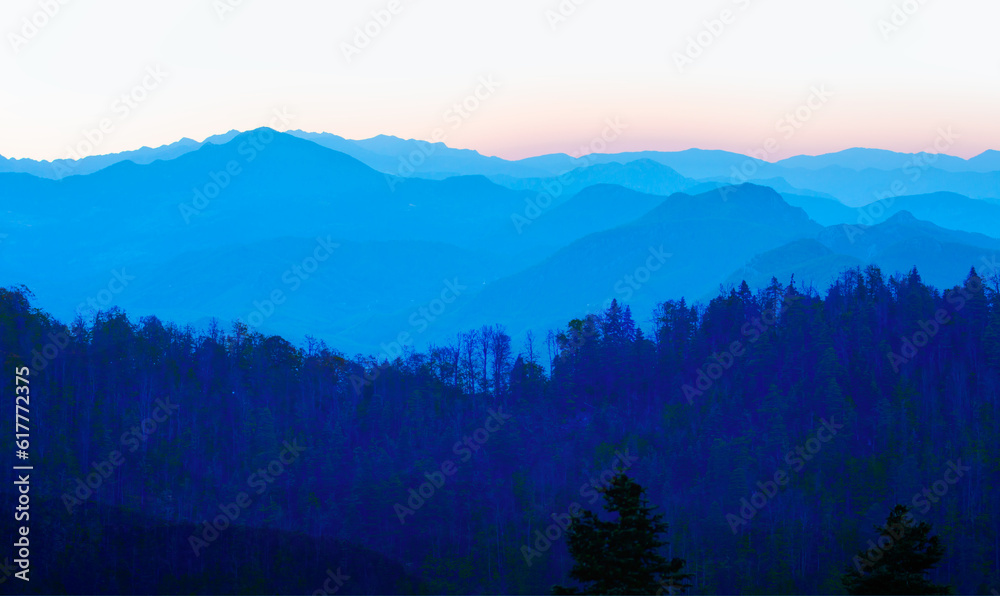 Beautiful landscape with blue misty silhouettes of mountains 