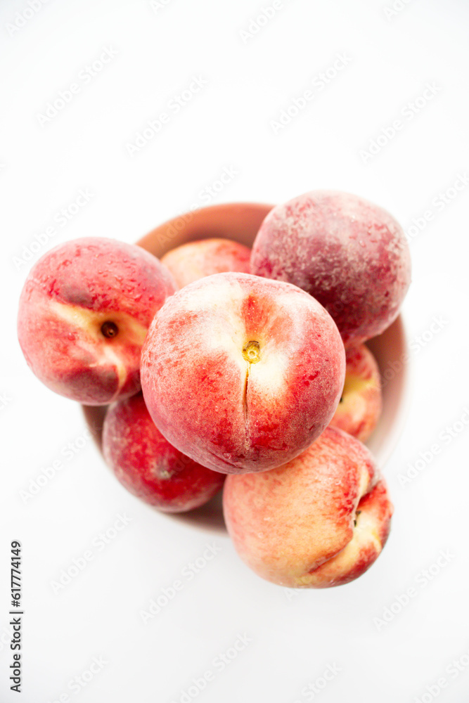 ripe peaches on a white background. top view. close up. fresh peaches in a bowl on a white background. ripe peaches on a white background. top view. close up. fresh peaches in a bowl on a white background.
