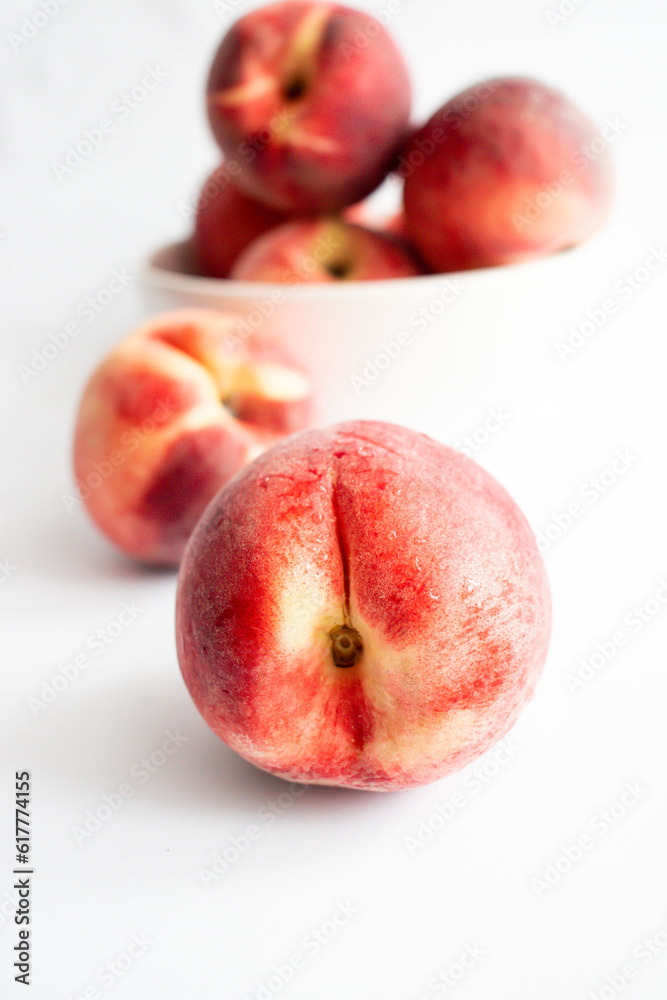ripe peaches on a white background. top view. close up. fresh peaches in a bowl on a white background. ripe peaches on a white background. top view. close up. fresh peaches in a bowl on a white background.