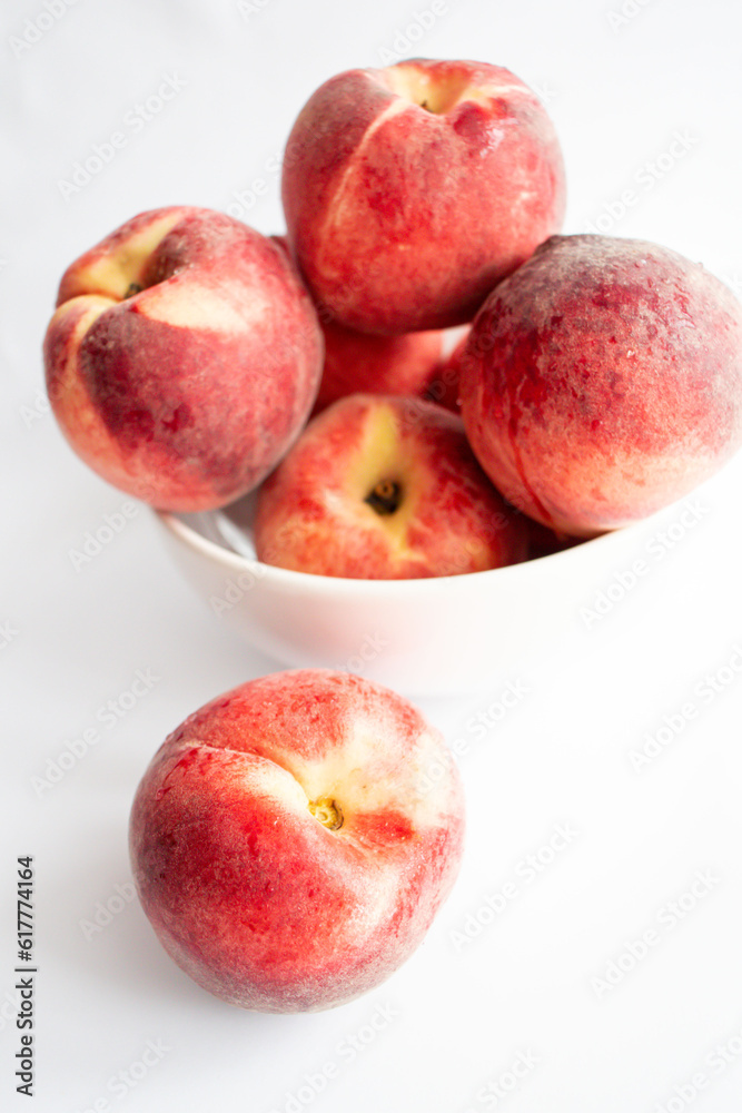 ripe peaches on a white background. top view. close up. fresh peaches in a bowl on a white background. ripe peaches on a white background. top view. close up. fresh peaches in a bowl on a white background.