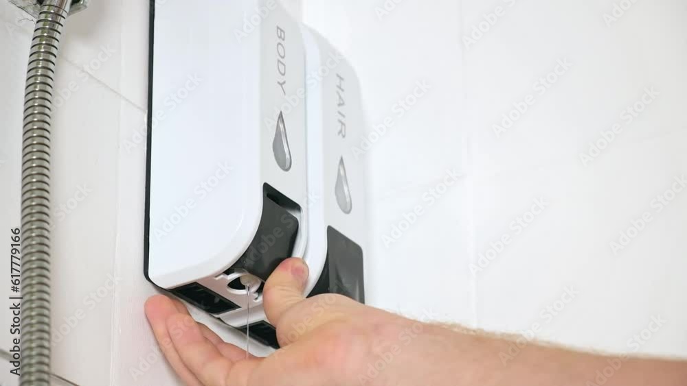 A man uses a shower gel using a Chamber Soap Dispenser Duo Shower Gel Shampoo Conditioner with Refillable Bottles Wall-mounted White. A man uses a shower gel using a Chamber Soap Dispenser Duo Shower Gel Shampoo Conditioner with Refillable Bottles Wall-mounted White.