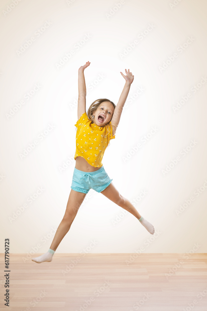 portrait of a little girl jumping while on a white background in a studio. happy joyful kid girl in comfortable trendy wear jumping high.. portrait of a little girl jumping while on a white background in a studio. happy joyful kid girl in comfortable trendy wear jumping high..