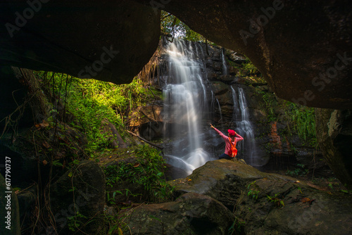 Young woman hiking on beautiful waterfall in Phu Wiang National Park, Tad Fah waterfall, Khon Kaen province, ThaiLand.