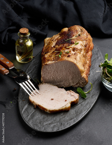 Baked piece of pork balyk on the table with spices. Tenderloin cut into pieces photo