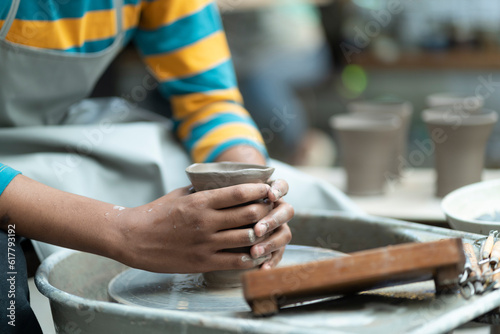 In an atmosphere of inspiration, an African American boy channels his creativity, transforming clay into inspired art pieces, leaving his unique mark in the ceramic studio.